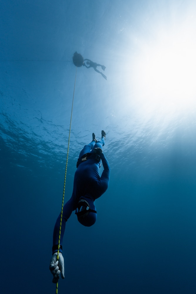 Freediver,Descends,Along,The,Rope,Into,The,Depth,While,Another
