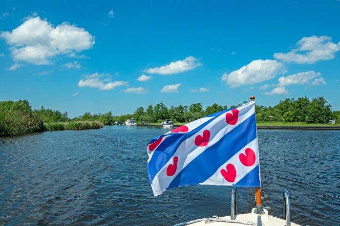Cruising,Through,National,Park,Alde,Feanen,In,Friesland,The,Netherlands Op het water met Friese vlag op dek