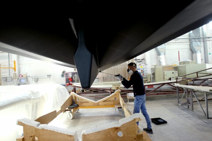 Pleasure,Boat,Factory, Monteur werkt aan onderkant boot